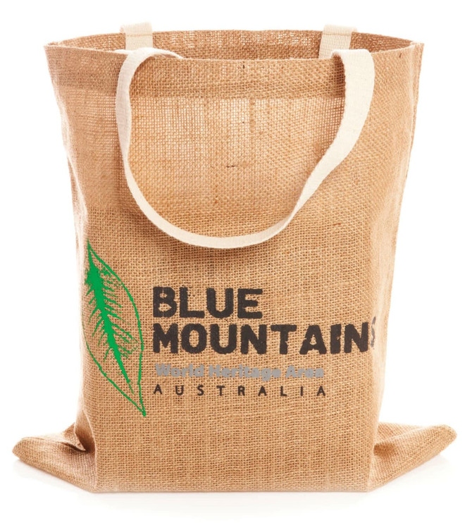 A jute shopping bag in a natural tan colour with a logo and fabric handles.