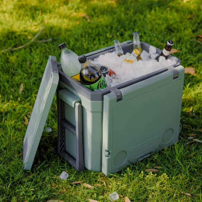 A green cooler box filled with ice and various drinks, featuring a lid partially opened.