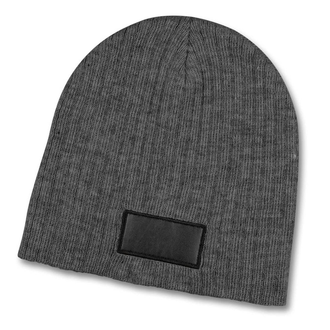A grey cable knit beanie with a textured fabric and a patch.