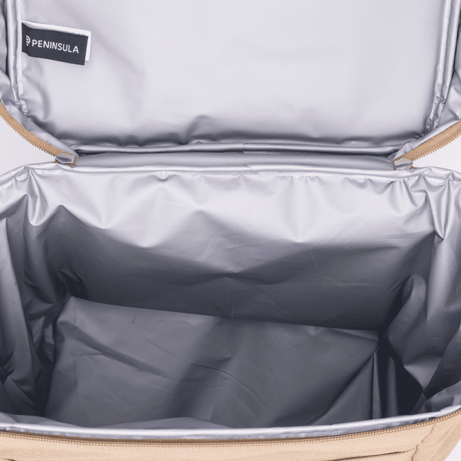 A tan cooler bag with a silver insulated interior, featuring a branded tag inside the lid.