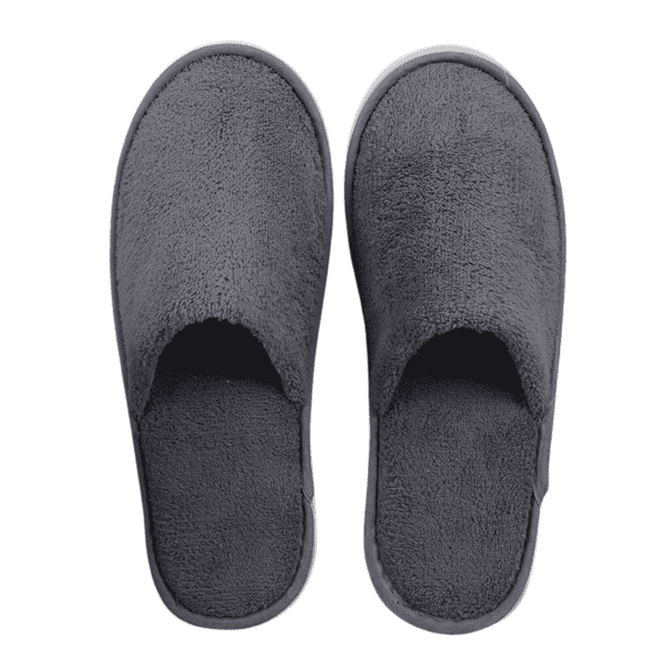 A pair of grey hotel slippers made from soft, plush material with an open-toe design.
