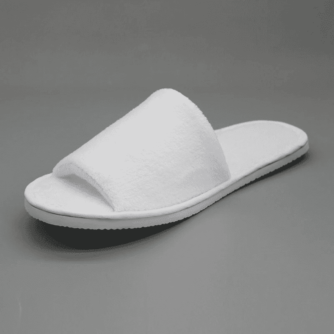 White open-toe hotel slippers with a soft fabric upper and flat rubber sole, featuring a simple design.