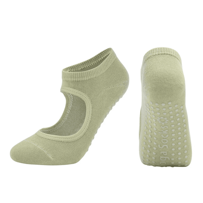 A pair of light green open-top yoga socks with a textured grip on the sole and a logo.
