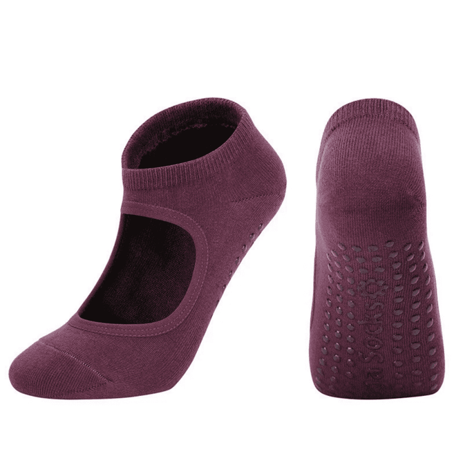 A pair of open-top yoga socks in a deep plum colour, featuring grip dots on the sole and a branded logo.