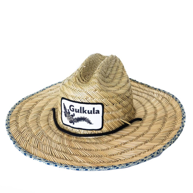 A straw hat in natural tones, featuring a wide brim and a central logo patch.