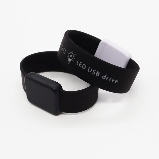 A black and white Arc Bracelet LED USB flash drive with a smooth, flexible silicone design.