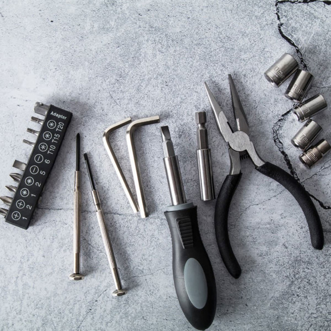 A 22-piece tool set featuring various metal tools, screwdrivers, pliers, and socket pieces in a sleek carry case.