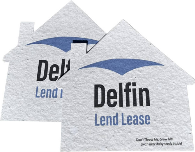 Two seed paper cards in the shape of houses, featuring a light blue roof and a logo, made from recycled material.
