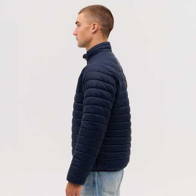 A navy blue puffer jacket, featuring a high collar and a quilted design, displayed on a model from the side.