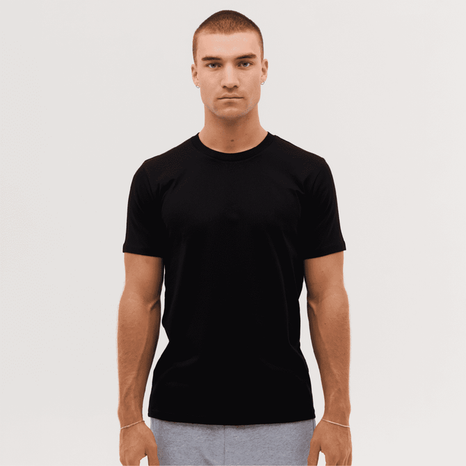 A plain black classic tee displayed on a model with short sleeves and a crew neck.