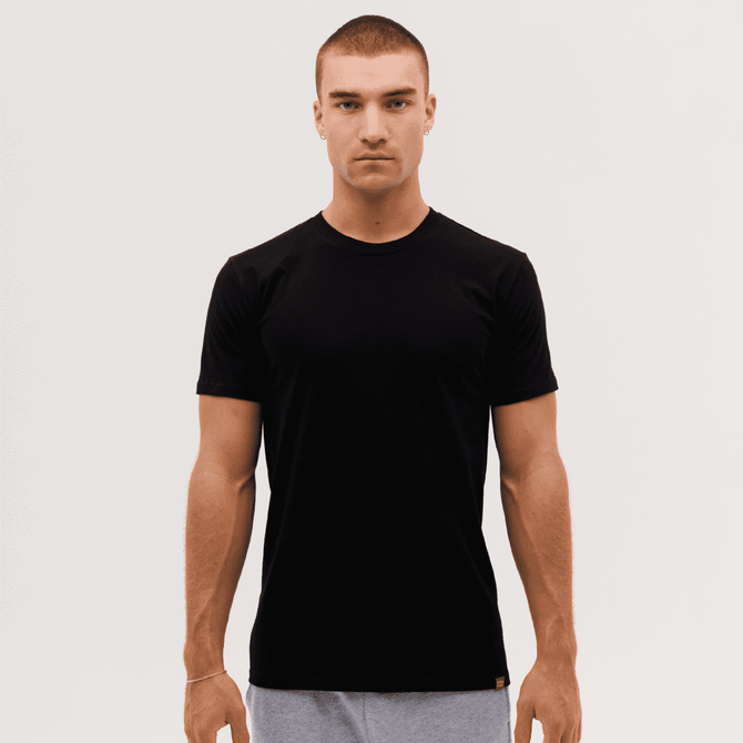 A black T-shirt displayed on a male model against a plain background, featuring a logo on the hem.