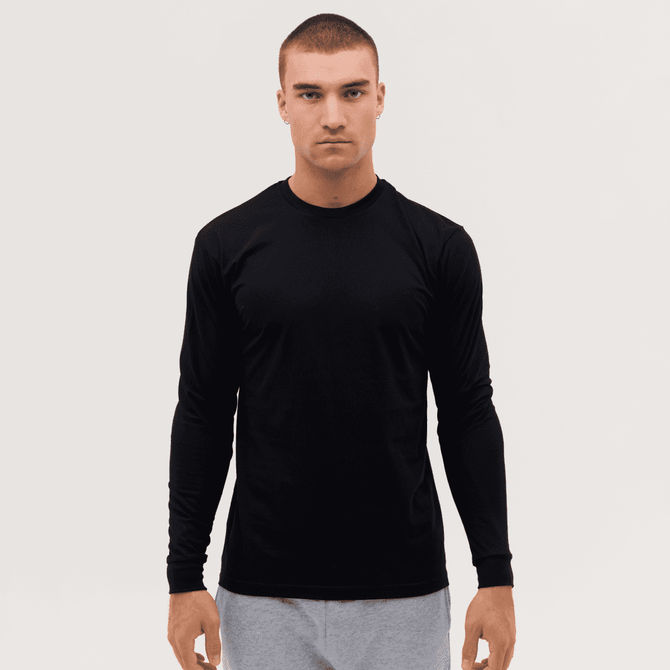A long sleeve tee in black, featuring a fitted design and a logo, worn by a model against a plain background.