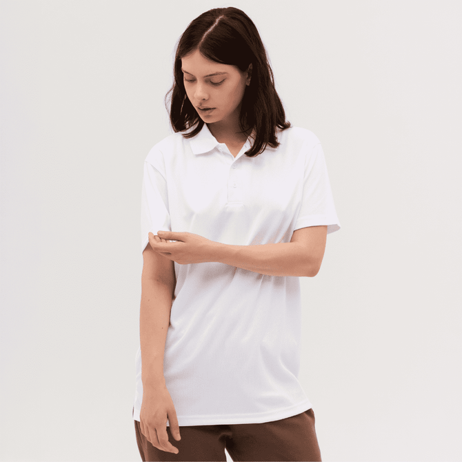 A woman wearing a white polo shirt, looking at her sleeve, set against a plain background. The shirt features a logo.