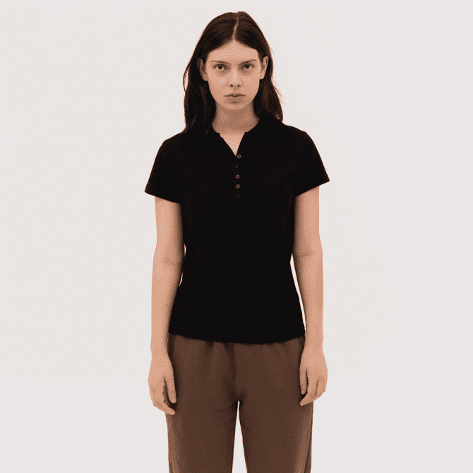 A women's black polo shirt with a button placket and short sleeves, featuring a logo on the chest.