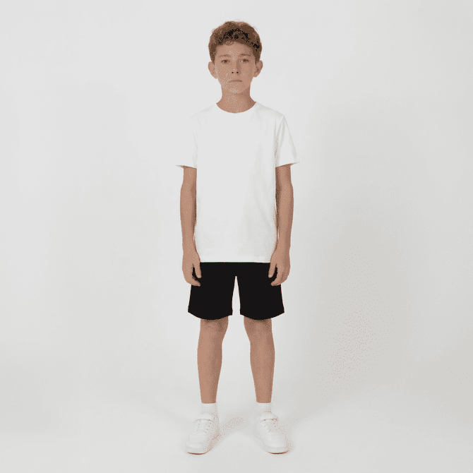 Youth Core Shorts in black, worn by a boy in a plain white t-shirt and white sneakers, standing against a plain background.