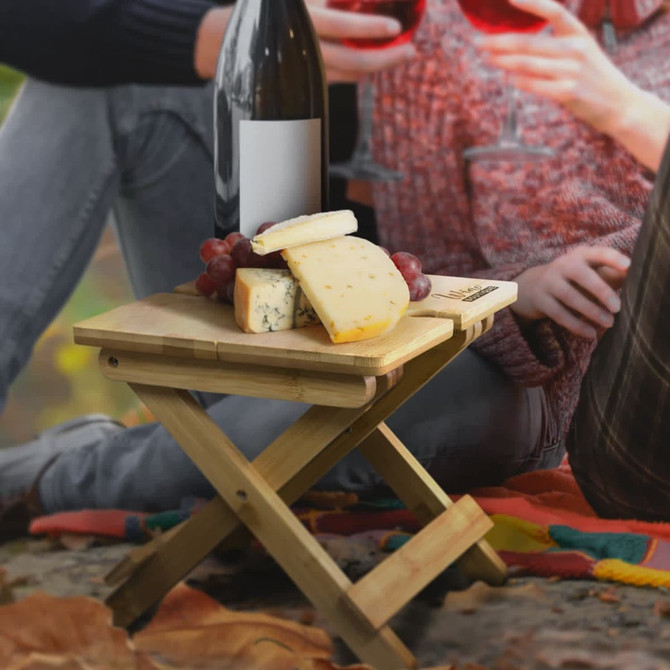 A bamboo folding wine table in a cardboard box, featuring a simple design and a logo on the packaging.