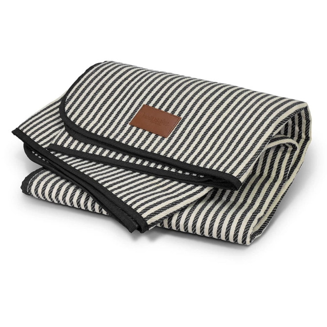 A striped picnic blanket in black and cream, neatly folded with a leather label.