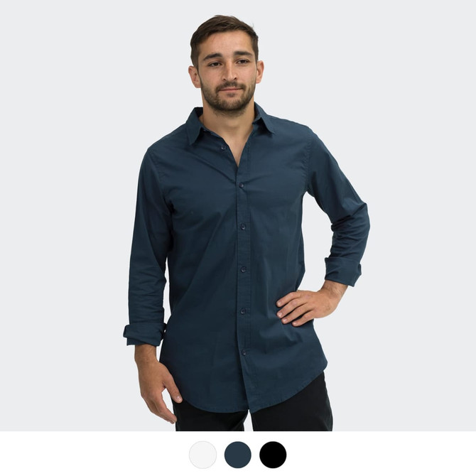 A man stands in a dark navy button-up shirt with long sleeves. The shirt features a logo on the chest.