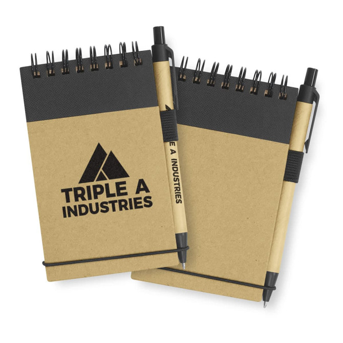 A brown recycled notebook with a black spiral binding and a matching pen attached. It features a logo on the cover.