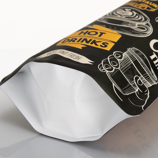 A large black foil stand-up pouch with a white interior, featuring illustrations and a logo.