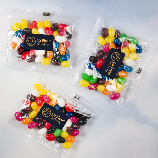 Assorted colourful mini jelly beans in clear cello bags, featuring a logo and a mix of vibrant hues.