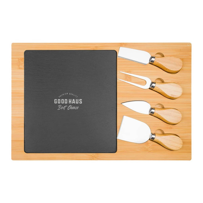 A bamboo cheese board with a black slate section and four stainless steel cheese knives with bamboo handles.
