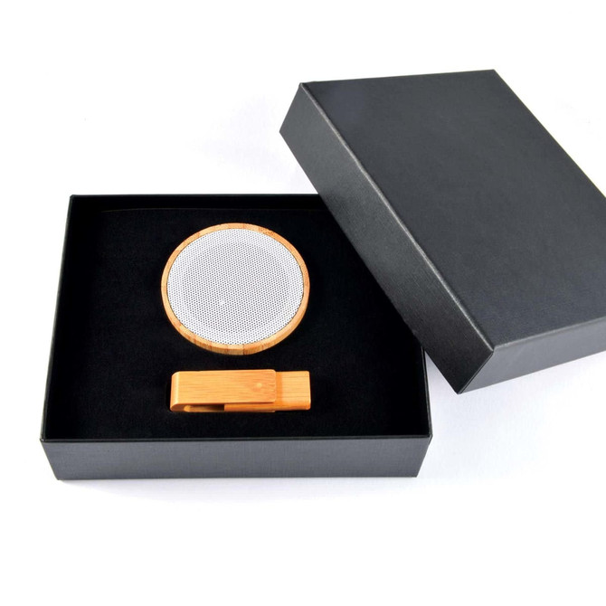 A sleek gift box containing a bamboo wireless speaker and a matching bamboo phone stand.