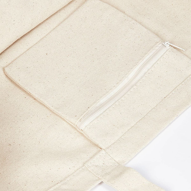 A cream-coloured canvas tote bag featuring a zippered pocket on the front. It has a simple, unembellished design.