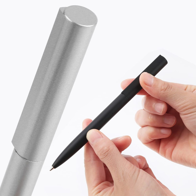 A silver metal pen case with a black metal pen held between fingers. The pen has a sleek design.