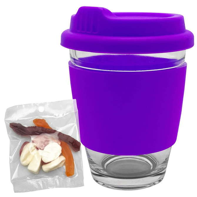 A reusable coffee cup with a purple silicone sleeve and lid, accompanied by a small pack of jelly lollies.