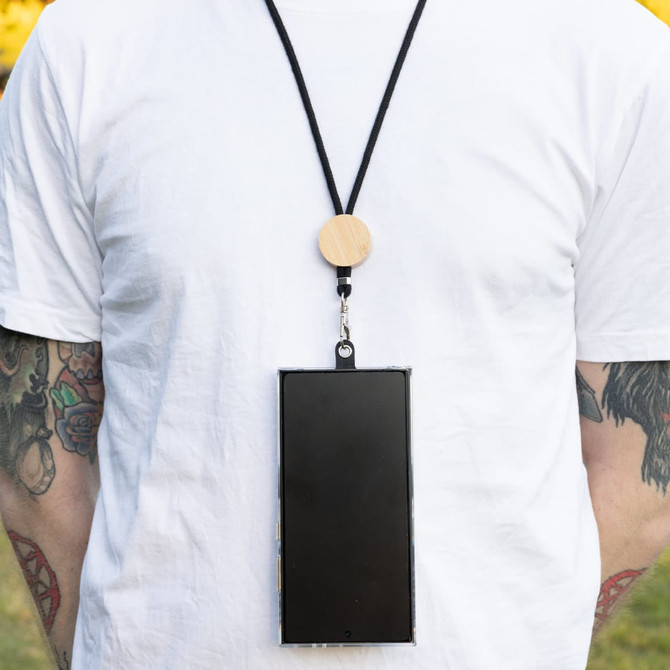 A phone neck lanyard displayed on a person, featuring a wooden clip and a black cord holding a smartphone securely.