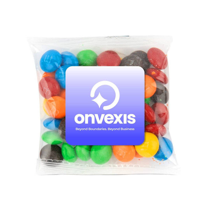 A clear pouch containing colourful chocolate-coated candies in red, blue, green, yellow, and brown. It has a logo on the front.