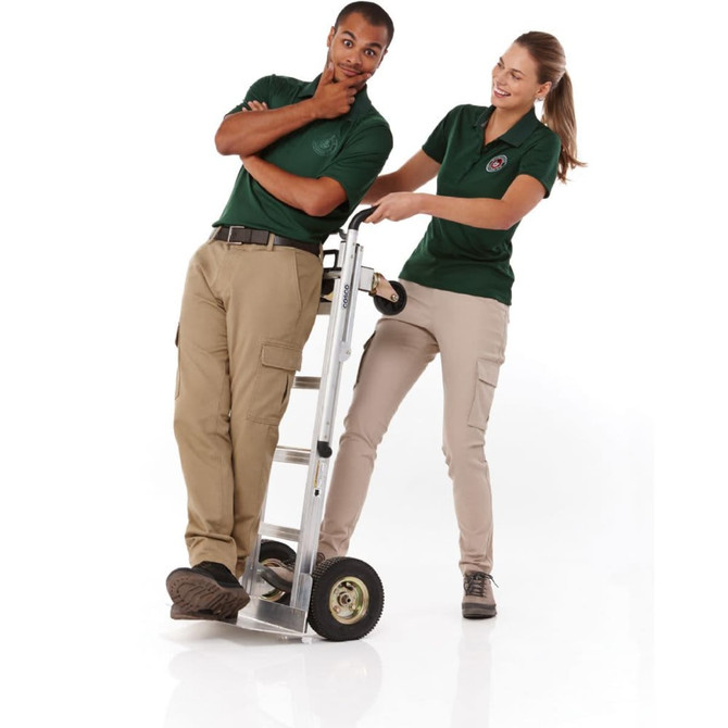A green women's polo shirt is worn by a woman, while a man leans on a ladder trolley. Both are smiling.