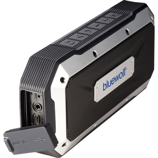A waterproof outdoor Bluetooth speaker in black and silver, featuring a protective casing and a hidden connection port.