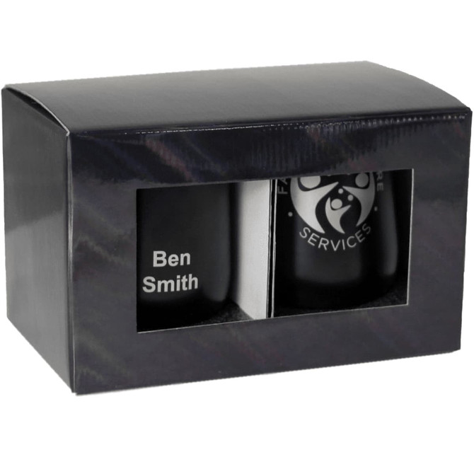 A gift box containing two black drinkware items, featuring one with a logo and another with personalised text.
