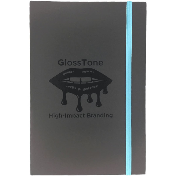 A black journal with a turquoise elastic band and a glossy lip graphic. It features a logo but no text.