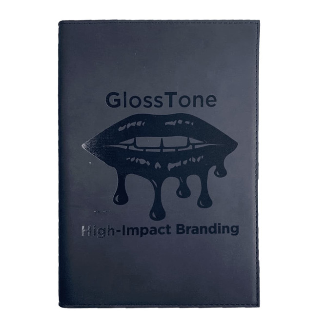 A black refillable journal with a glossy lip graphic and branding on the front cover.