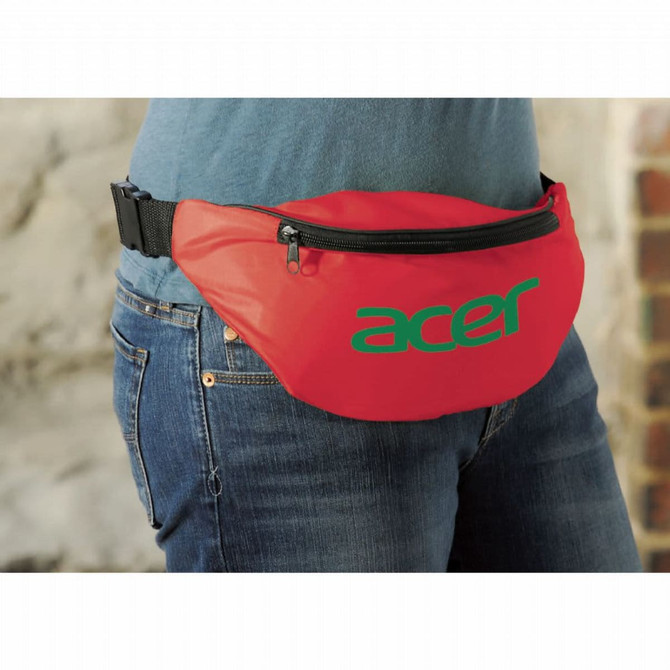 A red bum bag with a black zipper and a logo on the front, worn around the waist of a person.