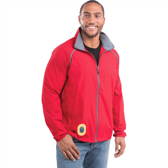 A man wearing a red packable jacket with a grey collar, featuring a logo on the front.