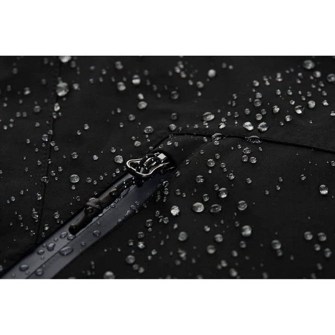 A close-up of a black softshell jacket featuring water droplets on the surface, highlighting its water-resistant fabric.