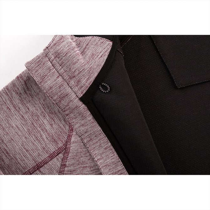 A close-up of a maroon and black zip hoodie featuring a textured fabric and an inner lining. It has a logo.