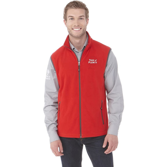 A man wearing a red polyfleece vest over a grey shirt, featuring a logo on the chest.