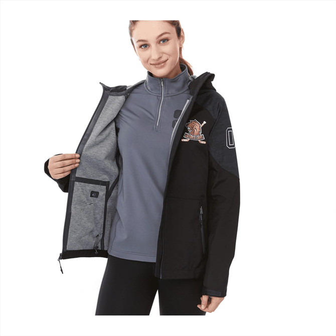 A woman wears a black softshell jacket open to reveal a grey interior. The jacket features a logo on the sleeve.