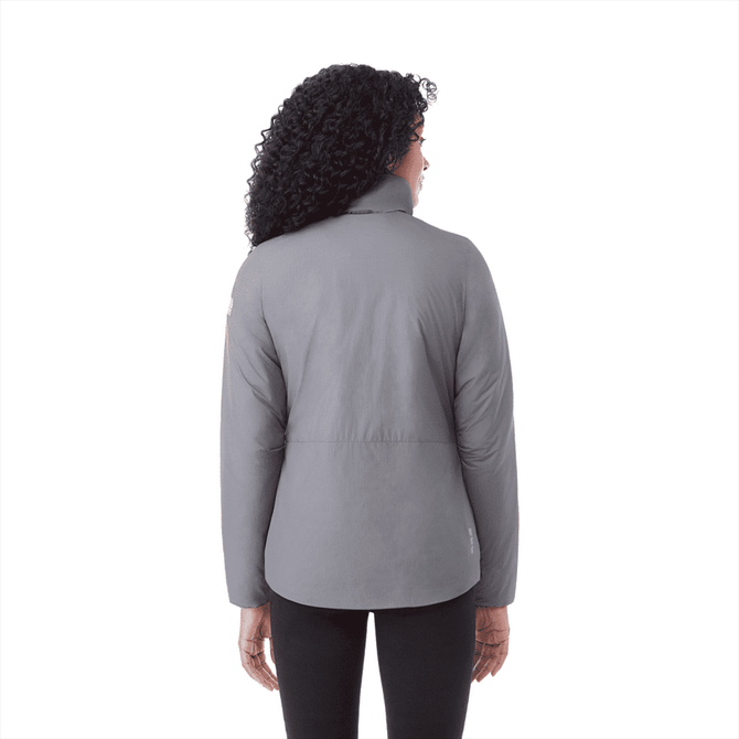 A woman wearing a grey insulated puffer jacket, shown from the back, featuring a logo on the sleeve.