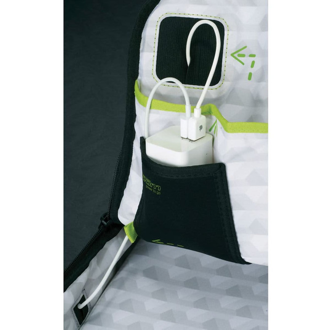 A close-up of a grey and green backpack pocket with a white charger plugged in and cables showing.