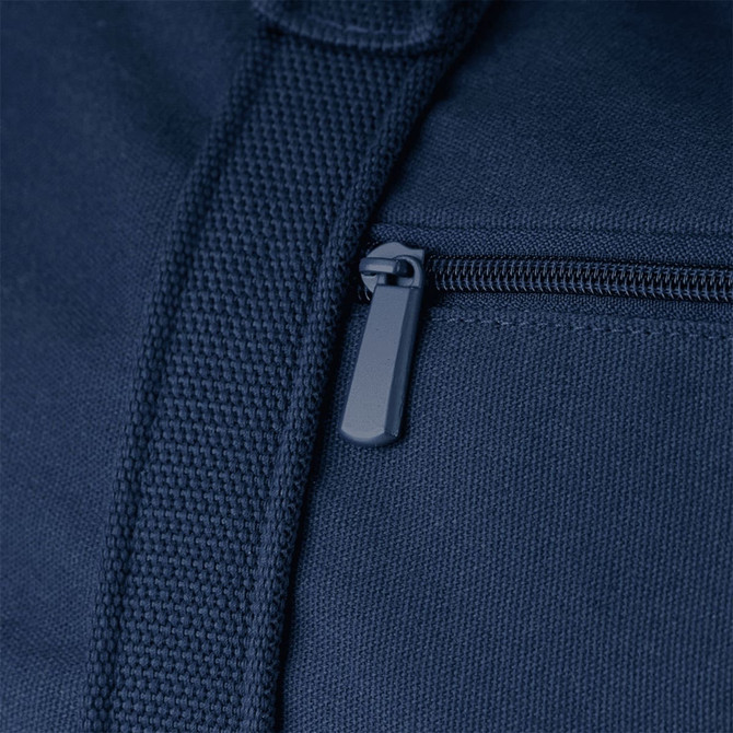 A close-up of a navy blue duffel bag featuring a zippered pocket and textured fabric. It has a logo present.