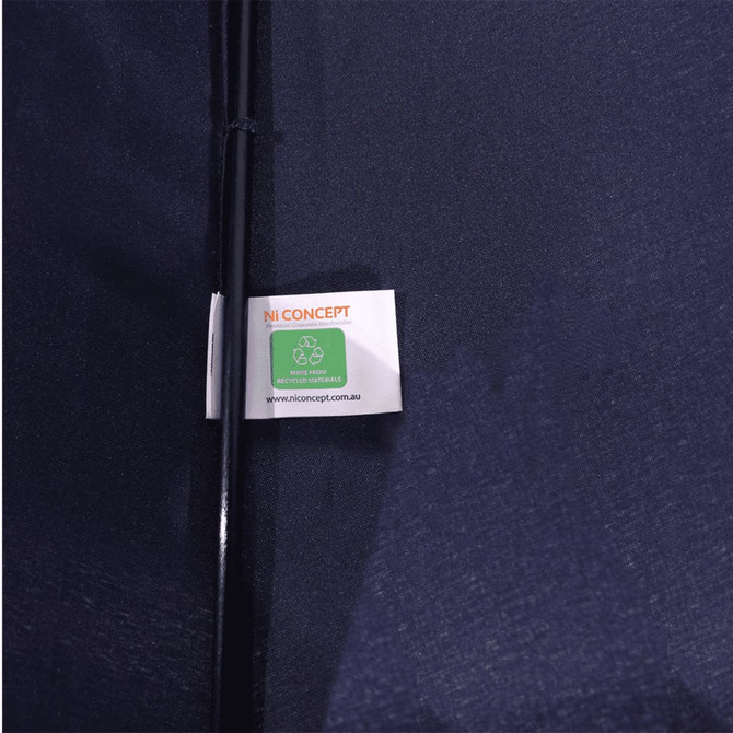 A navy blue vented tipless golf umbrella with a tag featuring a logo and recycling symbol.