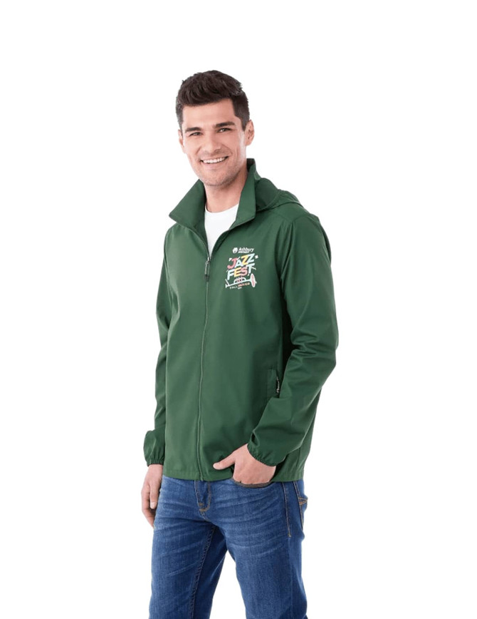 A man is wearing a green packable jacket with a hood and a logo on the front. The jacket is styled for rain protection.