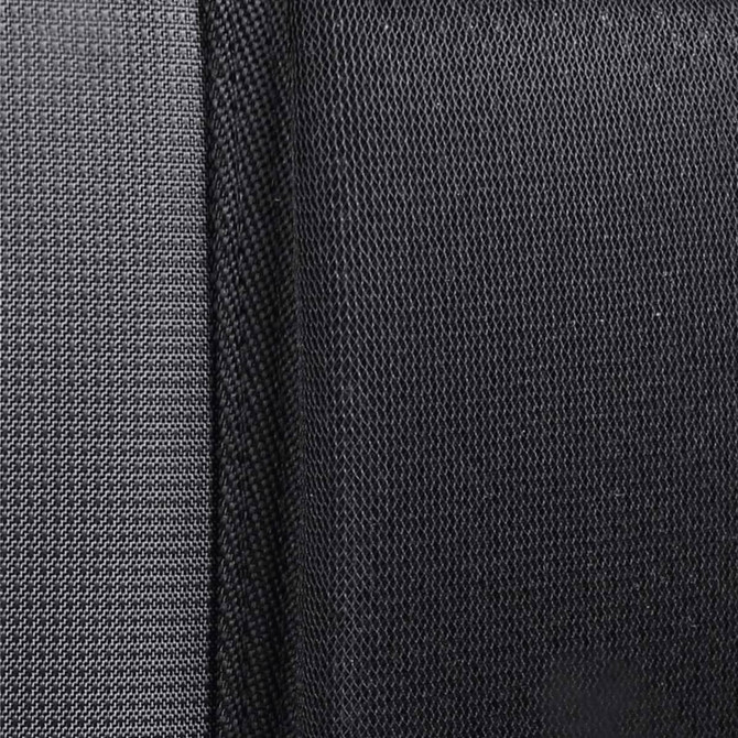 A close-up of textured fabric in dark grey and black, showcasing a layered design.