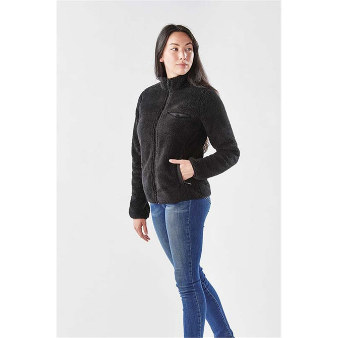 A black women's fleece jacket with a zip front and a chest pocket, worn by a woman against a light background.